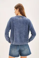 Sweater celeste de punto con diseño de trenzas, cuello redondo y corte holgado.