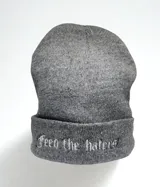 Gorro de lana sintética gris con la frase "Feed the Haters" bordada en blanco en el borde.