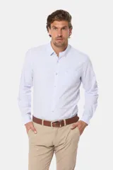 Camisa celeste a rayas verticales, de manga larga con opción de arremangar, corte slim fit y bolsillo en el pecho. Confeccionada en algodón.