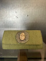 Sobre de fiesta color verde con aplique dorado en el centro y asa de cadena dorada.