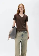 Remera gris de corte clásico, con cuello en V y mangas cortas.
