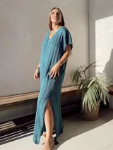 Vestido largo de tejido de punto calado color beige, con escote en V y mangas cortas.