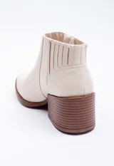 Botas marrones de símil cuero, tipo texanas, de caña baja y punta fina.