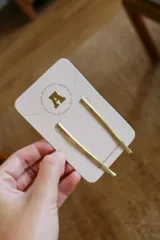 Par de caravanas doradas con forma de barra recta.