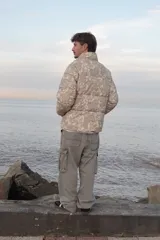 Campera puffer de corderoy con estampado paisley en tonos beige y cuello alto.