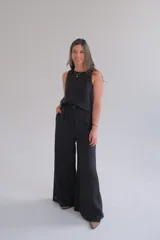 Pantalón negro de lino, de corte palazzo, con cintura alta y cierre con botón.