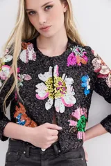 Saco corto negro con bordado de lentejuelas con forma de flores de colores. Tiene cuello redondo y ganchos invisibles al frente.