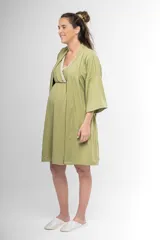 Bata corta color verde oliva, estilo kimono, confeccionada en algodón con textura acanalada. Tiene mangas 3/4, cuello en V cruzado y lazo para ajustar en la cintura.