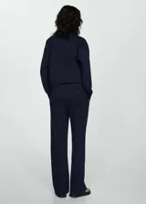 Pantalón de vestir color beige, de corte recto y tiro alto. Presenta cintura elastizada y bolsillos laterales.