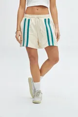 Short de felpa color beige con bolsillos laterales y cintas de color verde y azul.