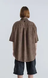 Camisa marrón de mangas cortas, corte holgado y cuello clásico.