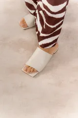 Sandalias de cuero vacuno color negro, con punta cuadrada y capellada amplia que cubre el empeine. Tiene taco bajo de 1 cm.