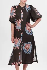 Vestido camisero midi de algodón y lino color gris con estampado de tigresas y flores en tonos azules y naranjas. Tiene cuello mao, mangas abullonadas cortas y cierre frontal con botones.