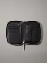 Billetera Calvin Klein negra acolchada con cierre de cremallera, logo plateado en el frente, cuatro ranuras para tarjetas, dos ranuras de seguridad, billetero y bolsillo monedero.