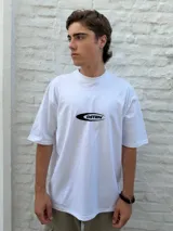 Remera blanca de corte oversize con un pequeño logo estampado en el pecho que dice "OSTEN" dentro de una forma ovalada negra.