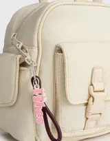 Cartera bowling negra de tela deportiva con manijas superiores y cierre superior. Tiene doble bolsillo frontal con hebilla, bolsillos laterales con broche y charm lateral.