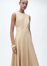 Vestido midi color beige, sin mangas, con cuello redondo y corte evasé.