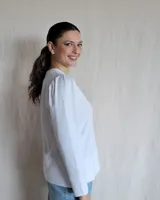 Remera negra de mangas largas con cuello en V y detalles de pespuntes blancos.