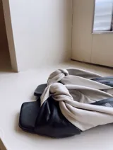 Sandalia de cuero ecológico con punta recta y detalle de nudo en el empeine, taco piramidal de 4 cm.