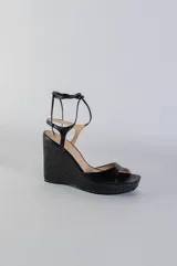 Sandalias negras de cuero con plataforma y tacón corrido de yute. Tiras finas de cuero que se atan al tobillo.