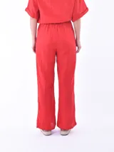 Pantalón de lino color rojo, de corte amplio y cintura elastizada con cordón ajustable.