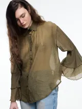 Camisa negra de lyocell y poliamida, con cuello clásico, mangas largas acampanadas con volados y cierre frontal con botones.