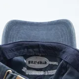 Gorra de gabardina azul con visera curva y ajuste trasero con hebilla metálica. Estampado frontal con la leyenda "Track and Field East Coast Est. 1978 Sports Symposium".