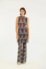 Vestido corto con estampado de tigres en tonos oscuros, confeccionado en tejido liviano y transparente. Presenta cuello alto y tirantes anchos, ideal para ocasiones casuales y estilos modernos.