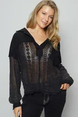 Camisa negra de manga larga con cuello, bolsillo en el pecho y corte relajado. Presenta paneles de rib contrastantes y paneles de crochet de encaje.