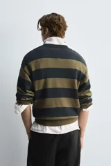 Sweater de punto a rayas horizontales en color verde oliva y azul marino, de corte relajado, cuello redondo y mangas largas con terminaciones acanaladas.