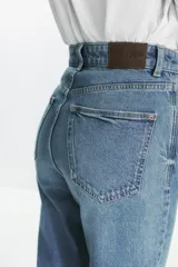 Pantalón de jean negro de corte recto, tiro alto y largo tobillero.
