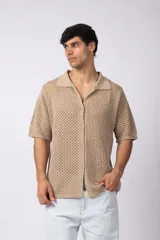 Camisa negra tejida de manga corta, con calado aireado, cuello tipo bowling y botones al tono. Diseño de corte relajado.