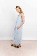Vestido largo de lino color celeste claro, con escote en V y breteles finos. Diseño holgado con bolsillos laterales.