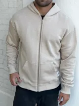 Campera de felpa color beige, con cierre frontal y bolsillos laterales.