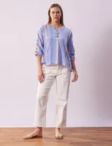 Blusa de algodón a rayas verticales en tonos celeste, rosa y blanco. Tiene cuello redondo con escote en V y abertura con botones de madera. Las mangas son 3/4 con aplique de botones.