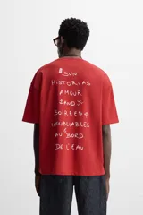 Camiseta roja de corte relajado, cuello redondo y manga corta. Estampado con texto en el frente y la espalda.