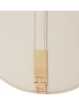 Cartera saddle color crema de Tommy Hilfiger, con correa ajustable y extraíble, cierre magnético, dos compartimentos principales y un compartimento con cremallera.