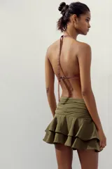 Falda pantalón corta color verde oliva, de tiro medio con detalle de pliegues en la cintura y volantes en el ruedo.