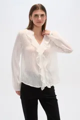 Blusa blanca de viscosa con cuello en V, volados frontales y cierre con botones.