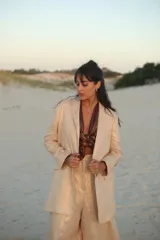 Blazer color beige con lurex, de corte recto y solapas clásicas.