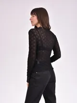 Remera negra de mangas largas con textura arrugada y transparente.