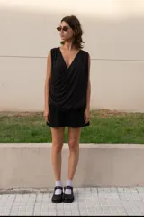 Minifalda negra de corte evasé con pretina elástica, bolsillos laterales y bolsillo trasero.