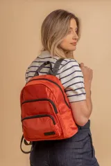 Mochila funcional color beige con detalles en negro, que incluye dos compartimentos con cierre y un bolsillo frontal para fácil acceso.