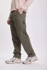 Pantalón verde de corte recto, estilo carpintero, con múltiples bolsillos y presillas para herramientas.