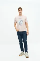 Remera color rosa pálido de manga corta con cuello redondo y estampado frontal con texto y diseño floral en tonos azules.