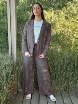 Blazer azul marino con rayas verticales blancas, confeccionado en lino italiano. Tiene botones de coco, solapas clásicas y bolsillos delanteros.