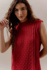 Vestido corto tejido color beige, sin mangas y con cuello redondo.