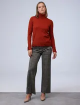 Polera de punto fino marca Nienty, color blanco, con cuello alto volcado y mangas largas con detalle de tajo en los puños.