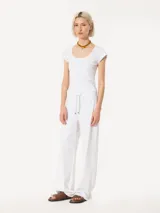 Remera blanca de algodón pima con escote en U, mangas cortas y logo bordado en la espalda.