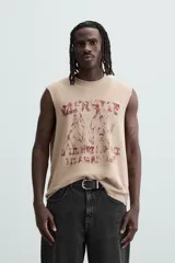 Camiseta sin mangas color beige con estampado de caballos en color borgoña.